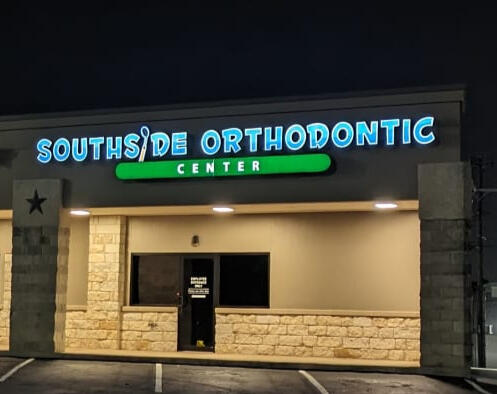 Night view of Southside Orthodontic Center storefront with illuminated blue and green channel letter sign after reface.