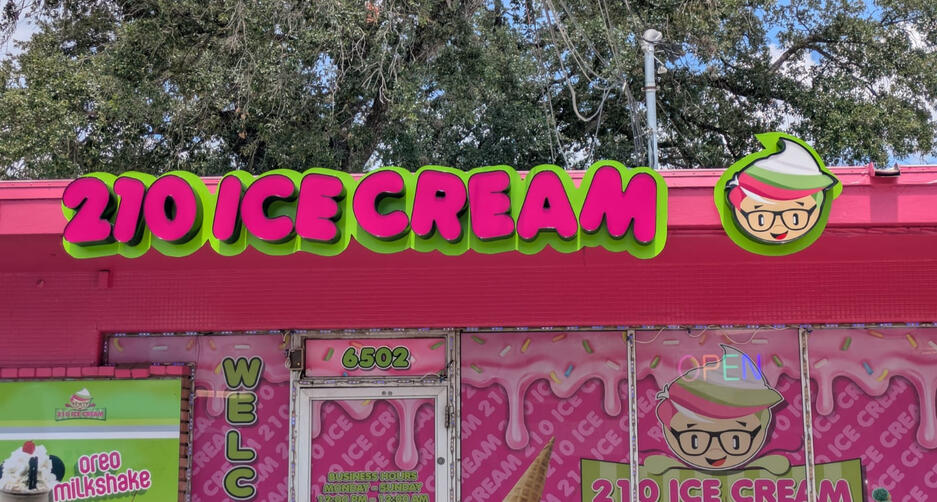 Bright pink and green channel letter sign reading ‘210 Ice Cream’ with cartoon ice cream logo on storefront.